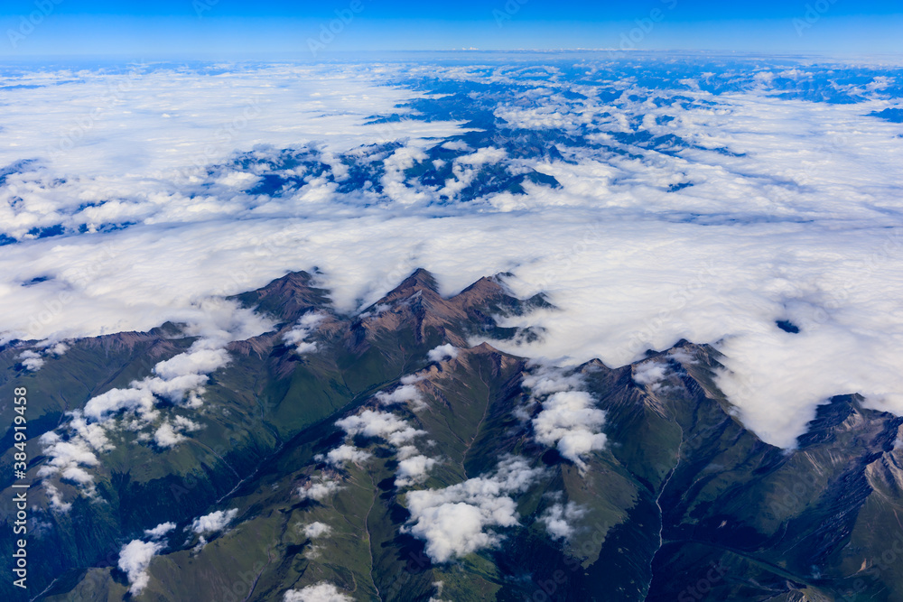 Aerial view above the clouds and mountain peaks on a sunny day.mountain view from airplane.