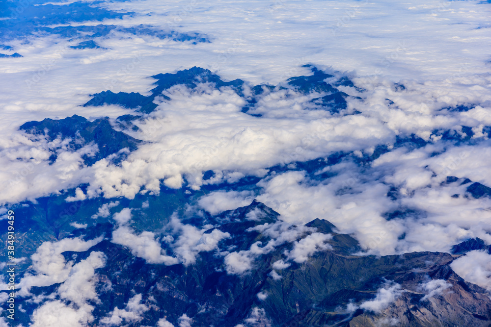 Aerial view above the clouds and mountain peaks on a sunny day.mountain view from airplane.