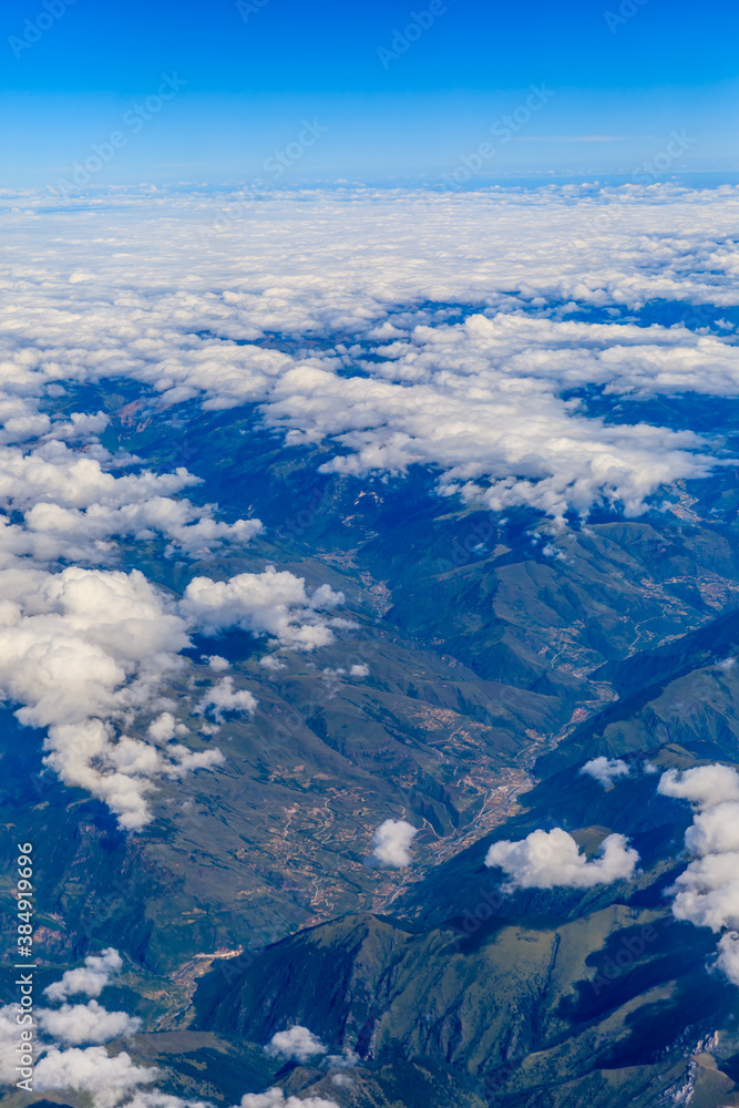 Aerial view above the clouds and mountain peaks on a sunny day.mountain view from airplane.