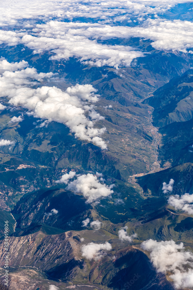 Aerial view above the clouds and mountain peaks on a sunny day.mountain view from airplane.