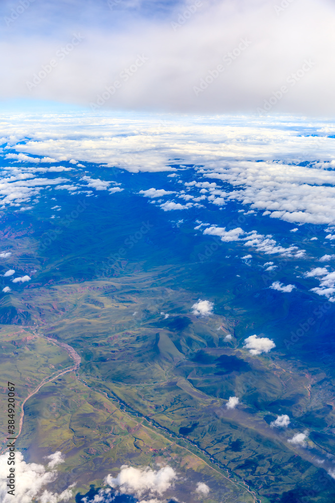 Aerial view above the clouds and mountain peaks on a sunny day.mountain view from airplane.