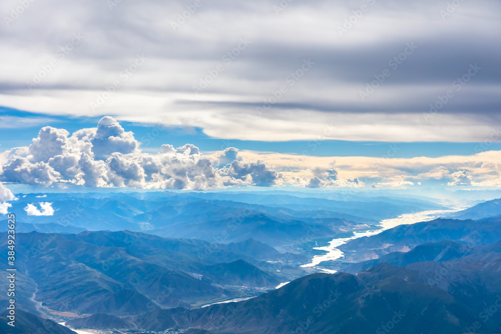 在阳光明媚的日子里俯瞰云朵和山峰。从飞机上俯瞰山景。