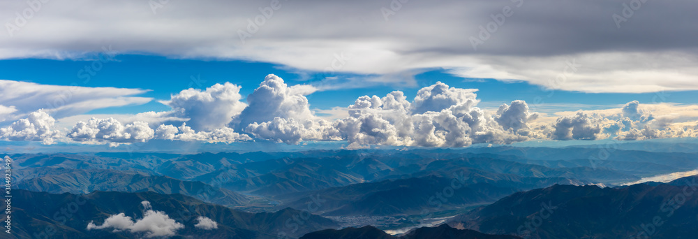 在阳光明媚的日子里俯瞰云朵和山峰。从飞机上俯瞰山景。