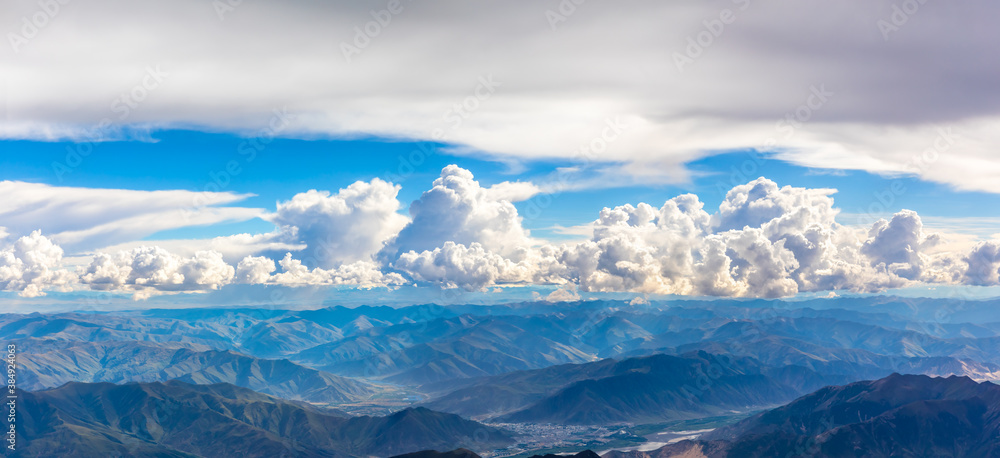 Aerial view above the clouds and mountain peaks on a sunny day.mountain view from airplane.