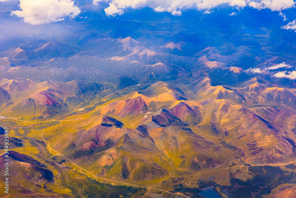 Aerial view above the clouds and colorful mountain on a sunny day.mountain view from airplane.