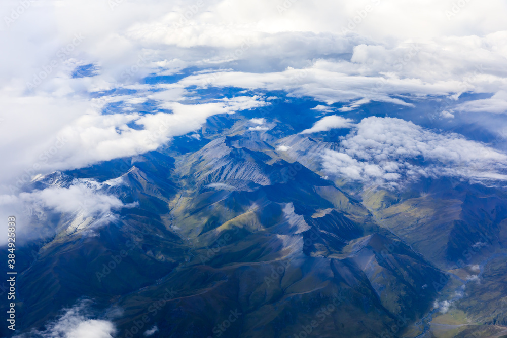 Aerial view above the clouds and colorful mountain on a sunny day.mountain view from airplane.