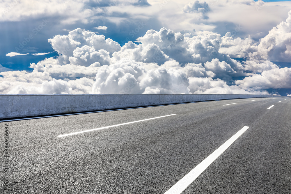 Empty asphalt road and blue sky with white clouds scenery.