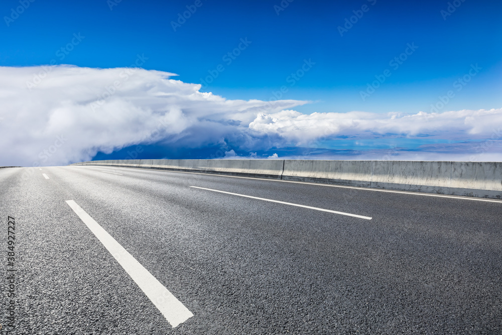 Empty asphalt road and blue sky with white clouds scenery.