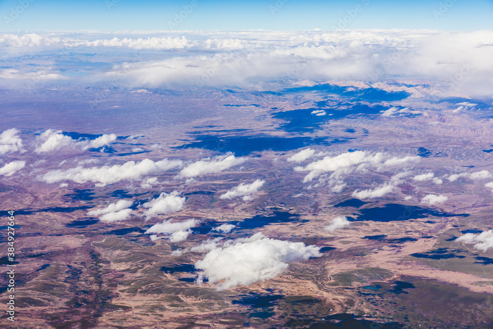 Aerial view above the clouds and mountain peaks on a sunny day.mountain view from airplane.