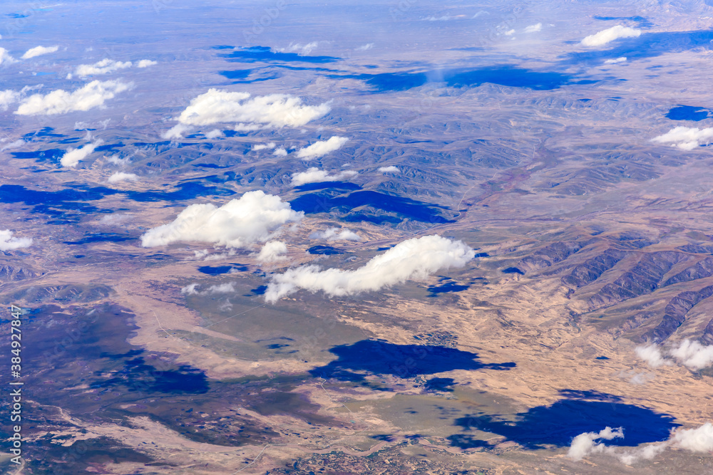 Aerial view above the clouds and mountain peaks on a sunny day.mountain view from airplane.