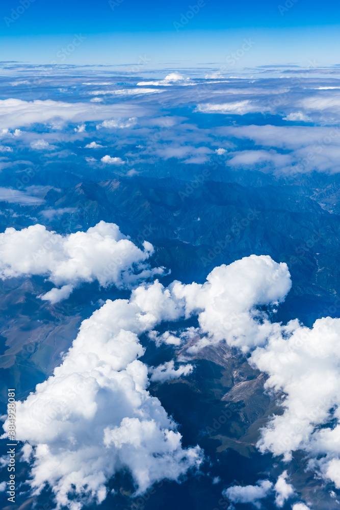 Aerial view above the clouds and mountain peaks on a sunny day.mountain view from airplane.