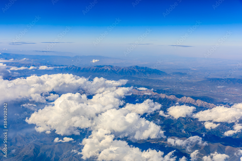 Aerial view above the clouds and mountain peaks on a sunny day.mountain view from airplane.