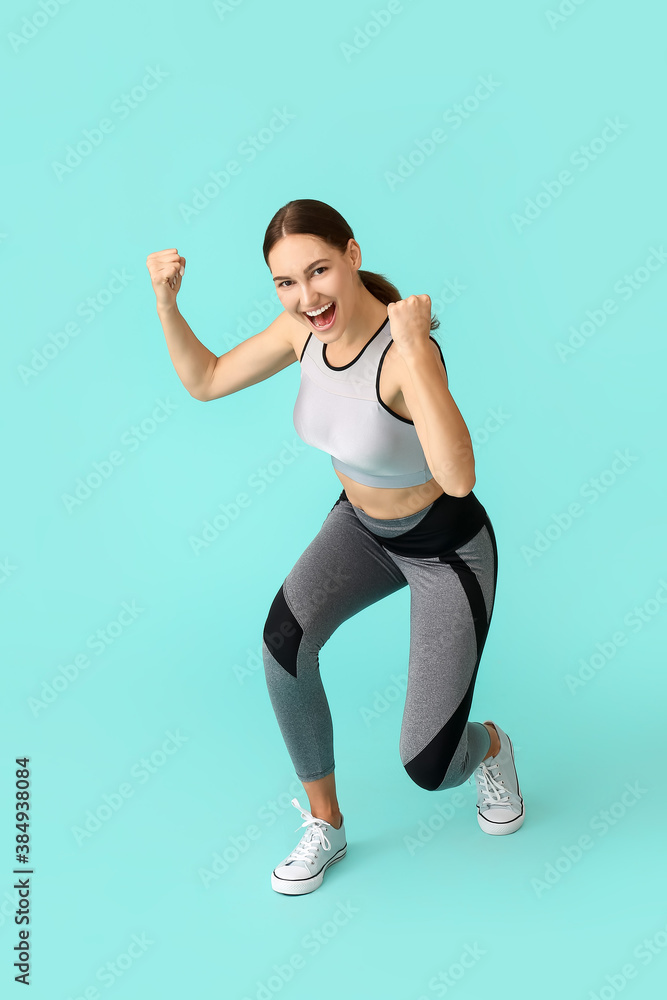 Happy sporty young woman on color background. Concept of goal achievement