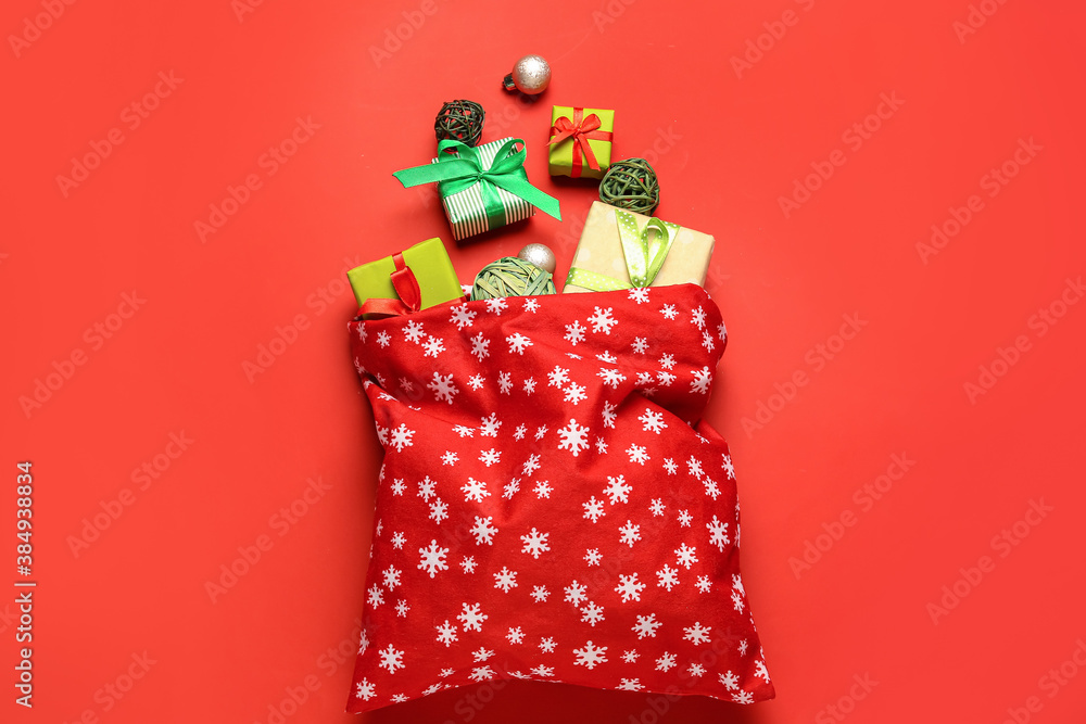 Santa bag with gifts on color background