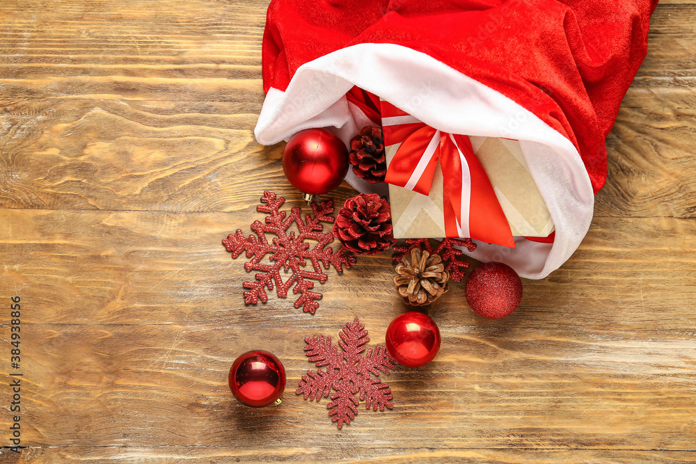 Santa bag with gifts and decor on wooden background