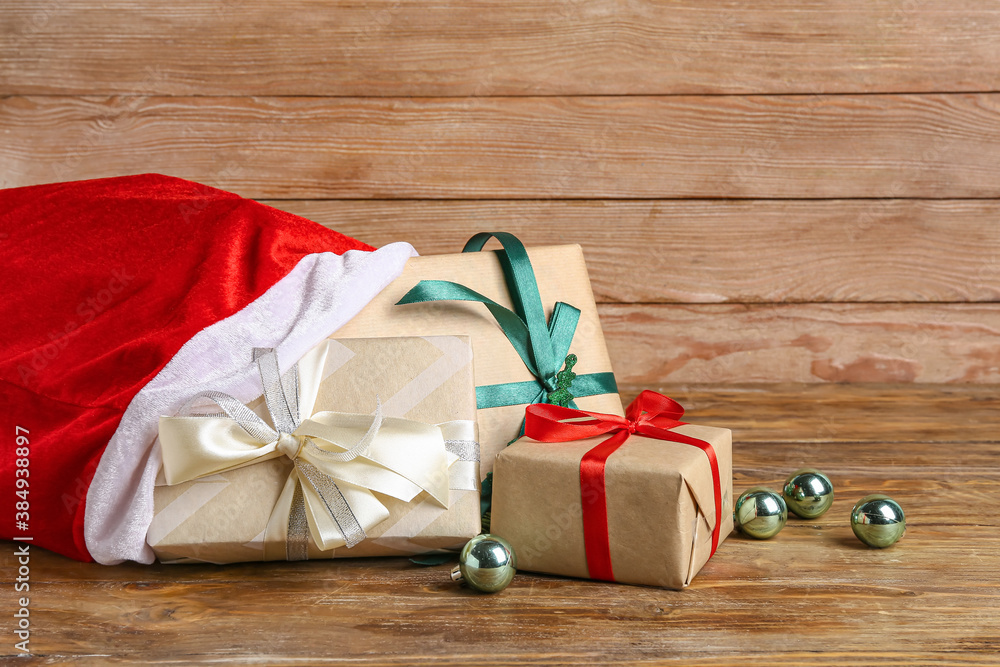 Santa bag with gifts on wooden background