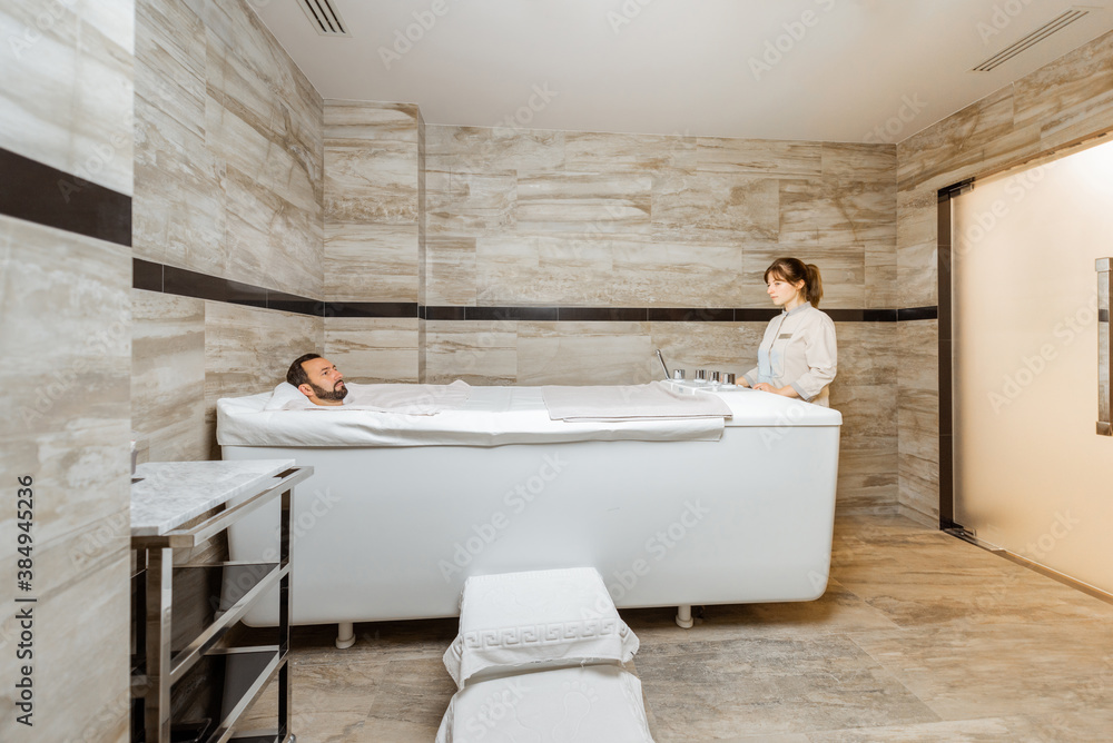 Man relaxing during a medical treatment at the bath filled with carbon dioxide at balneology room wi