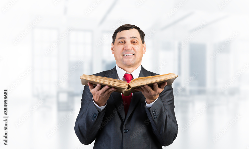 Happy senior businessman holding open book