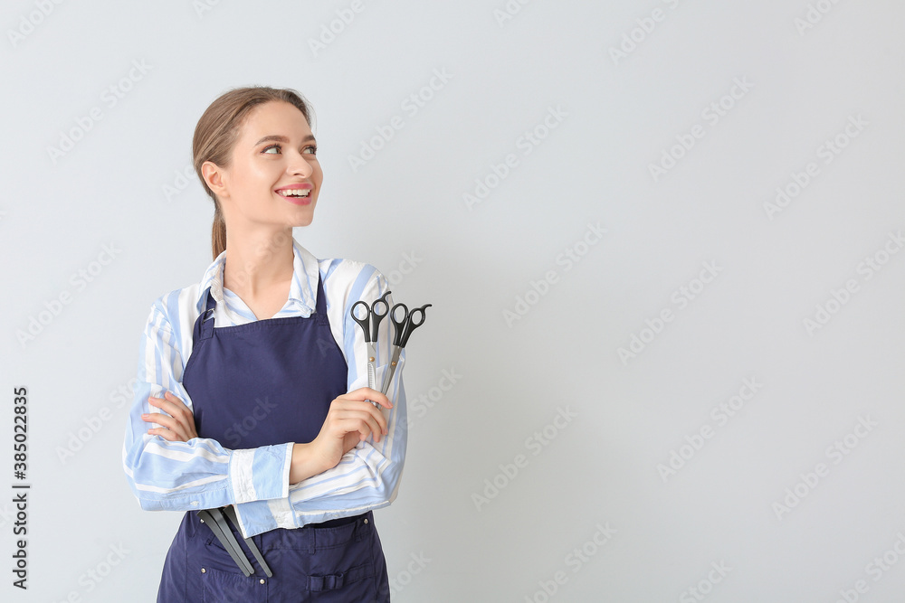 Female hairdresser on light background