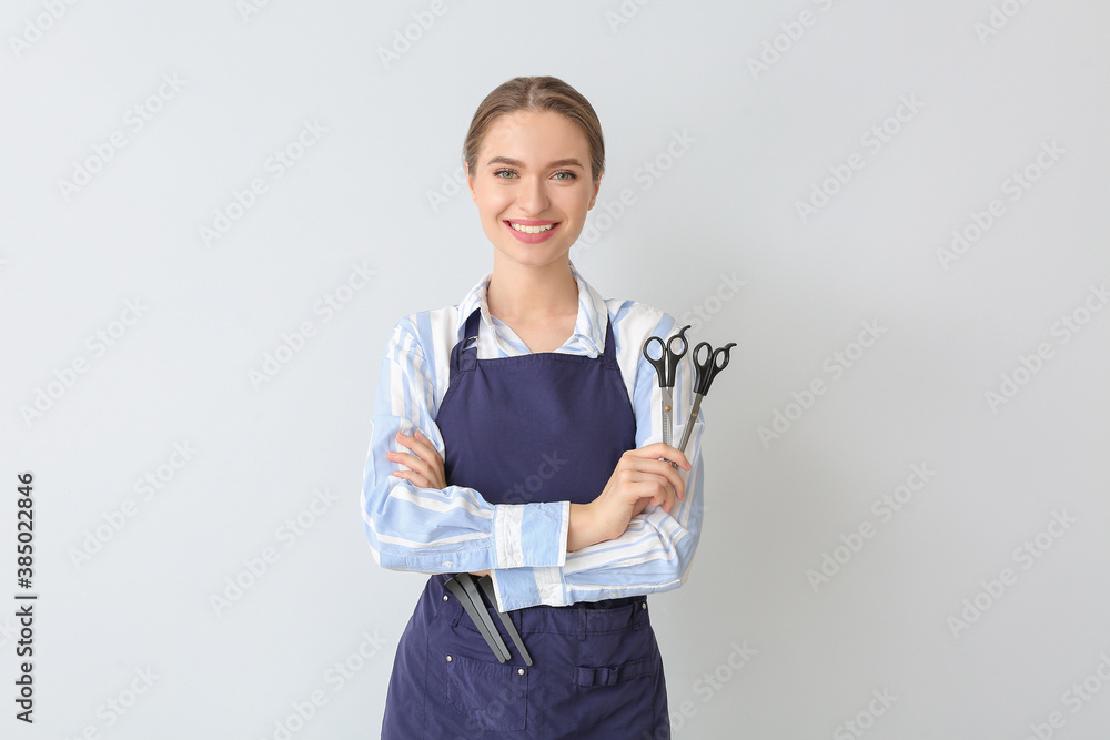 Female hairdresser on light background