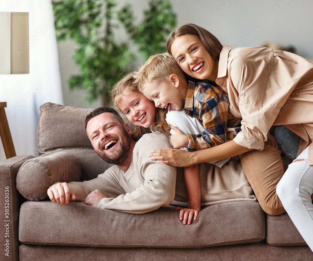 happy family mother father and kids at home on couch .