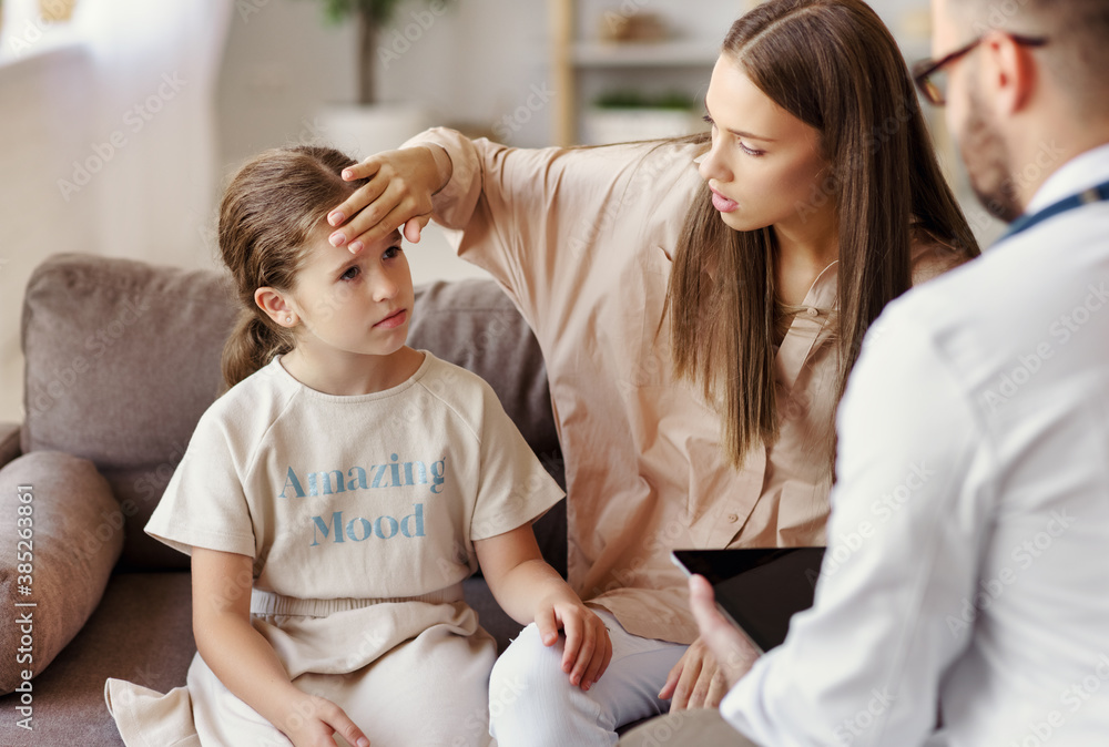 family doctor pediatrician conducts examination of  ill child girl   with his mother.