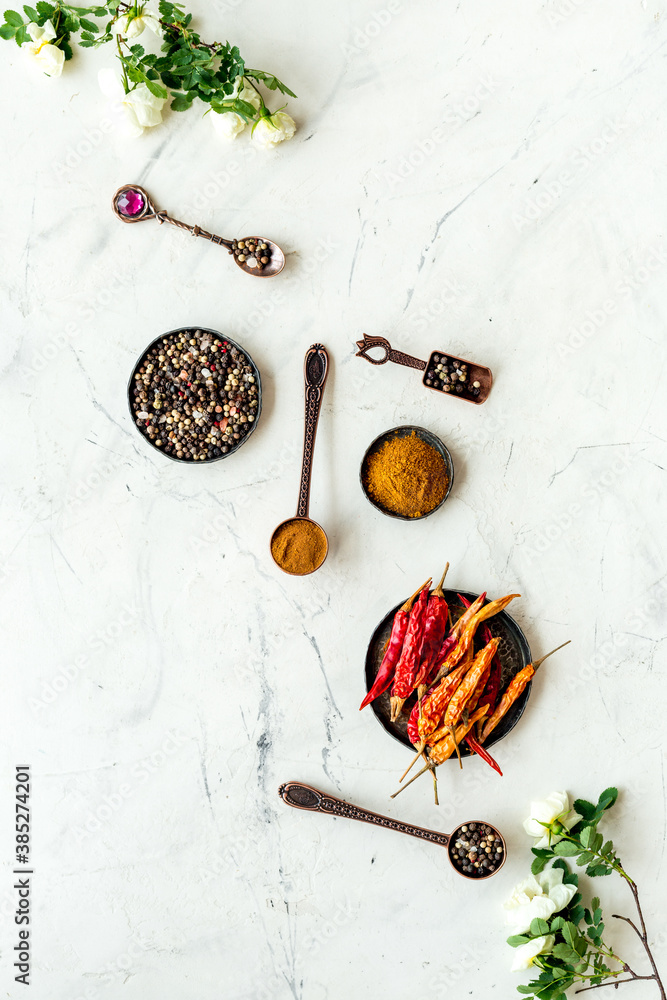 Cooking utensils and hot spices in metal bowls and spoons. Top view