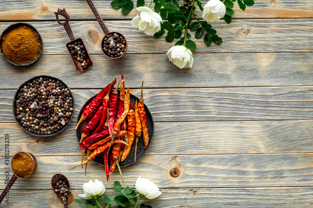 Mix of spices in metal spoons and bowls, flat lay