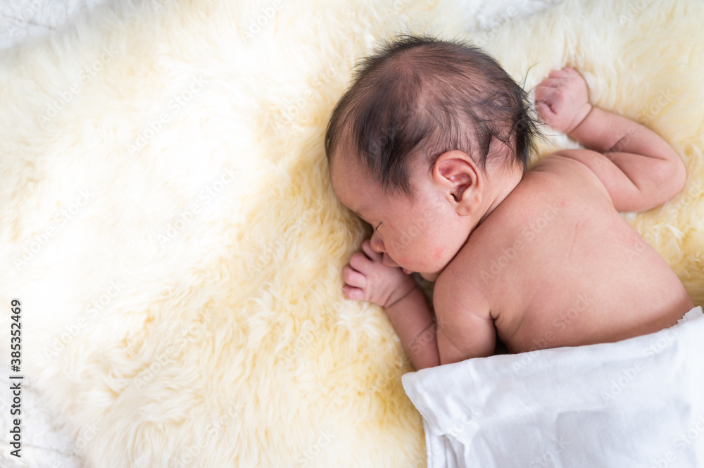 Newborn baby in costume sleeping on blanket