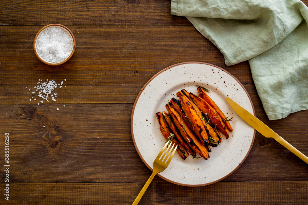 Sweet potato fries with spices on a wooden board, top view