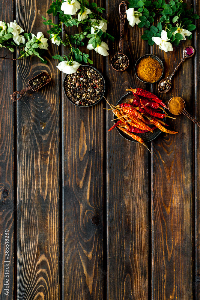 Mix of spices in metal spoons and bowls, flat lay