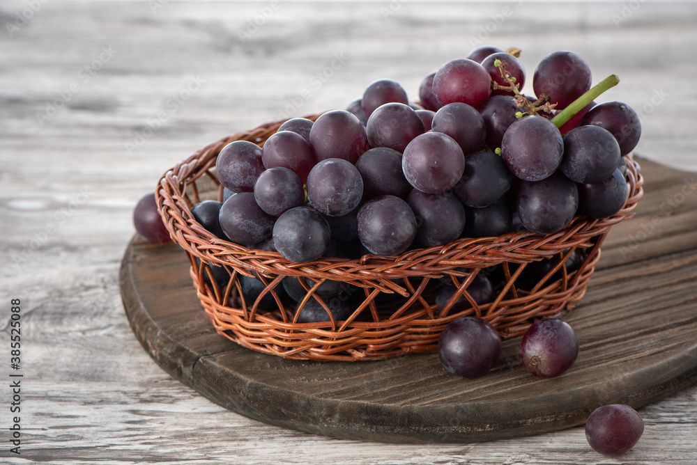 Close up of bunch of grapes fruit over wooden table background.