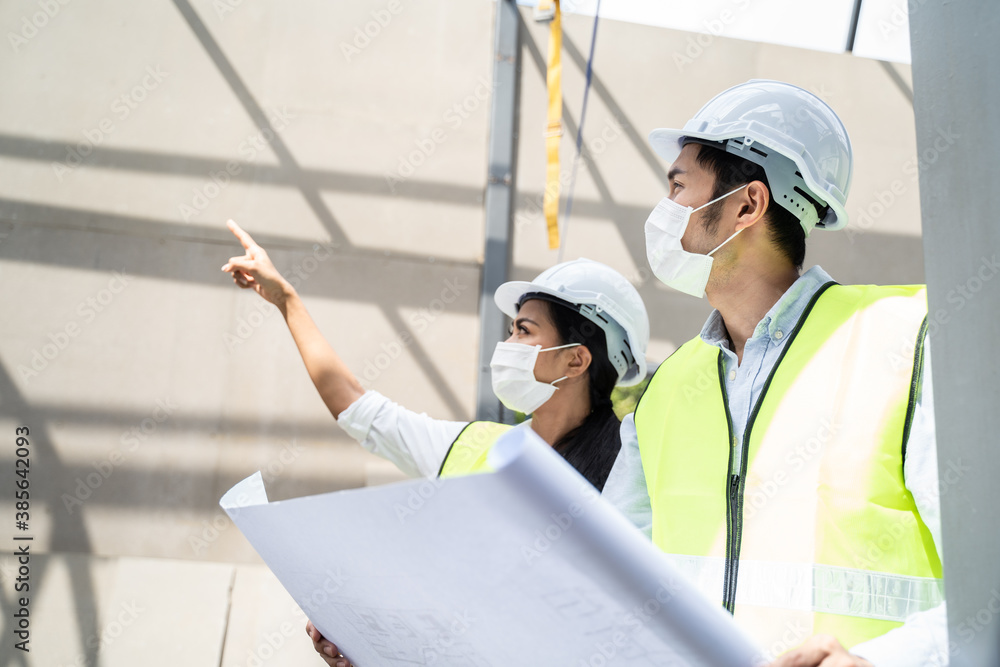 Asian young engineer man and woman looking on drawing and explaining.