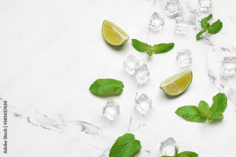 Ice cubes, lime and mint on light background