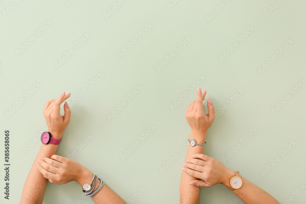 Female hands with watches on color background