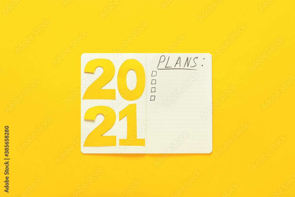 Notebook with word PLANS and figure 2021 on color background