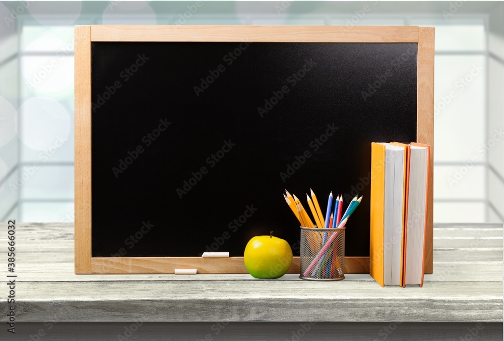 Blackboard with wooden frame and apple on the desk