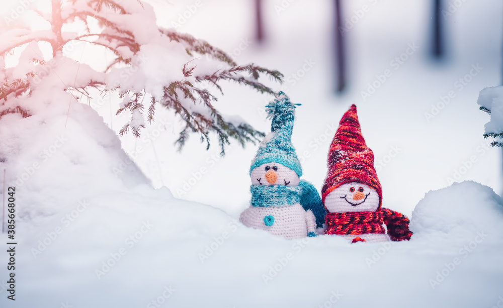 little snowmans on soft snow on blue background