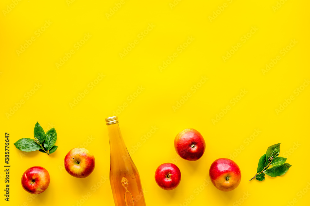 Bottle of vinegar with red apples. Top view, copy space