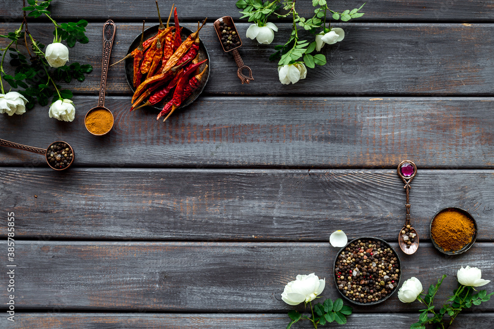 Set of spices and herbs for cooking in metal spoons and bowls, top view