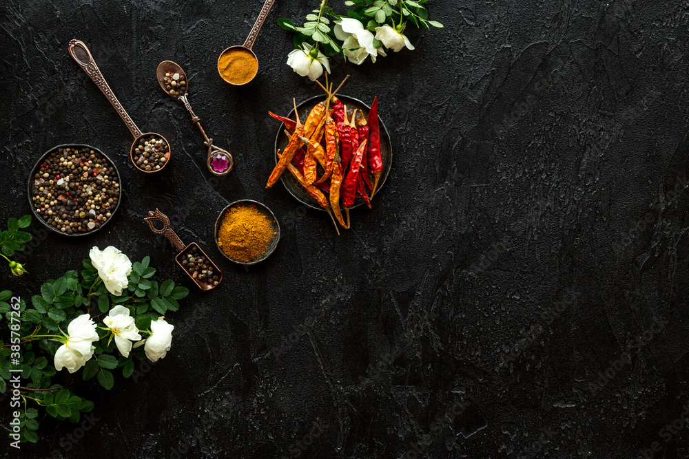 Cooking utensils and hot spices in metal bowls and spoons. Top view