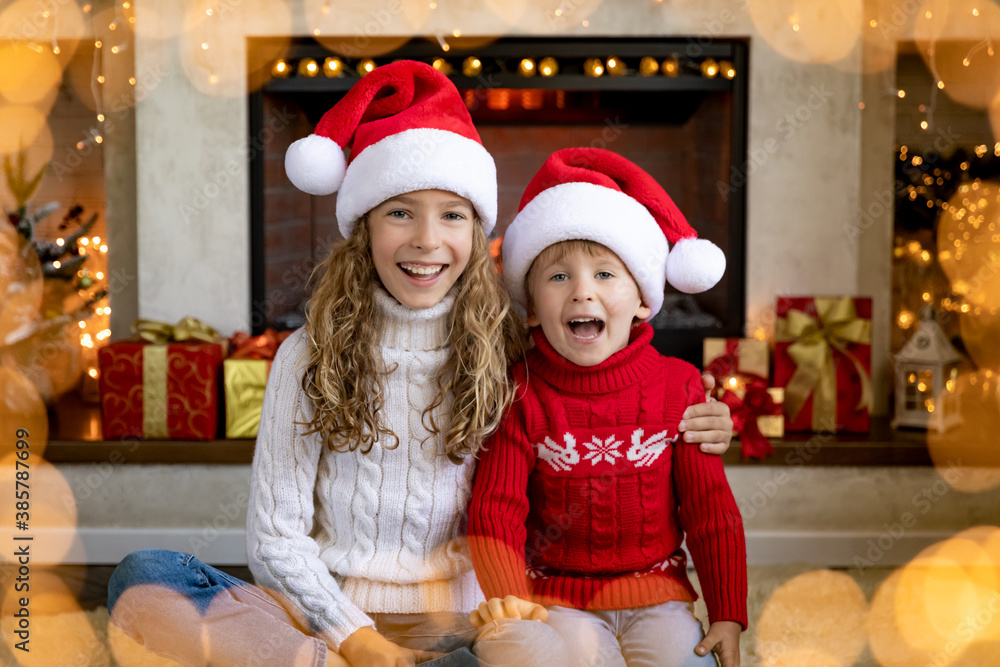 Happy children near fireplace at Christmas