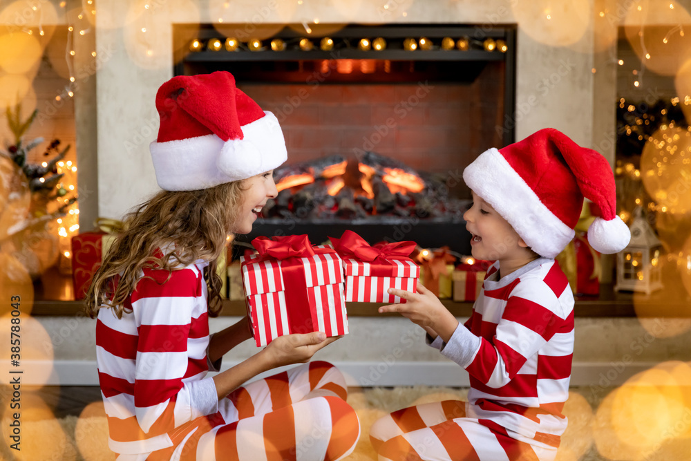 Happy children near fireplace at Christmas