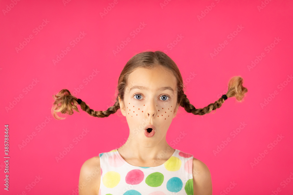 Surprised girl against pink background