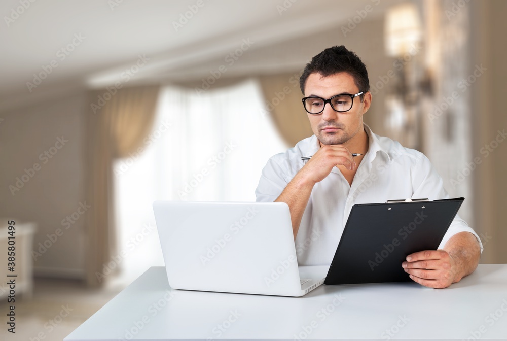 Young handsome man in glasses using laptop