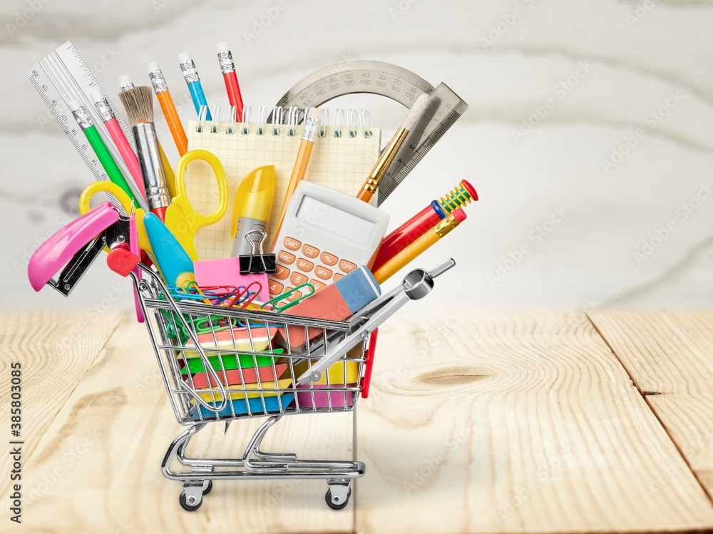 Stationery objects in mini supermarket cart on desk