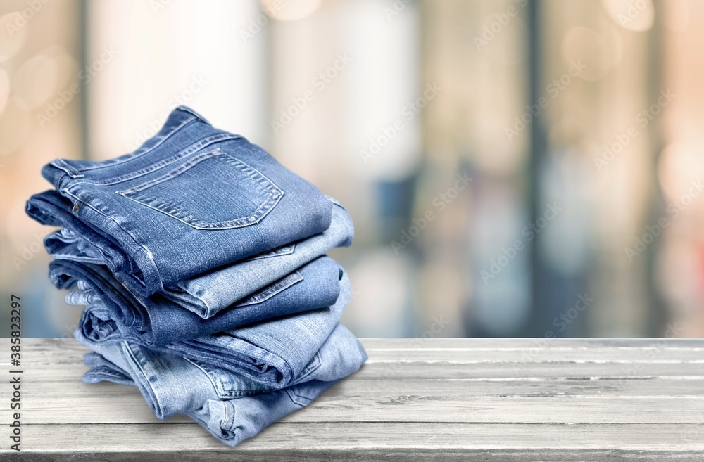 The pile of blue jeans over the wooden desk