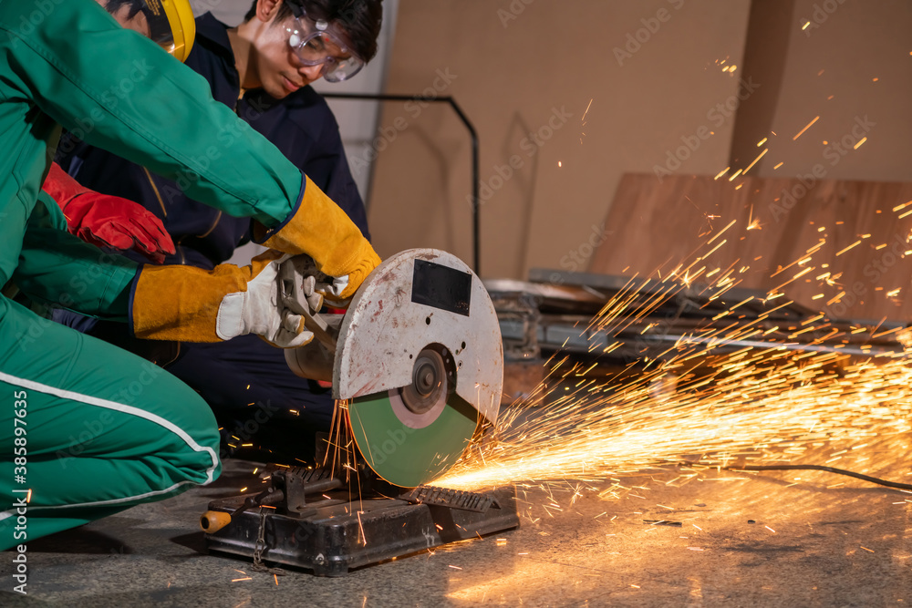 Professional mechanic man is cutting steel metal with rotating carbon blade cutter. Steel industry a