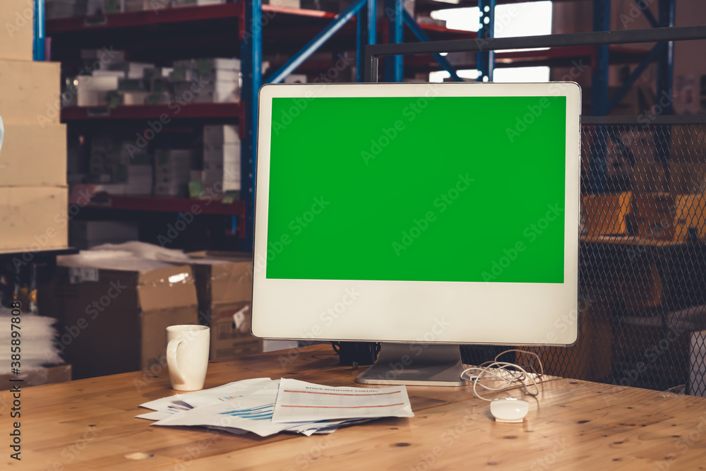 Computer with green screen display in warehouse storage room . Delivery and transportation software 