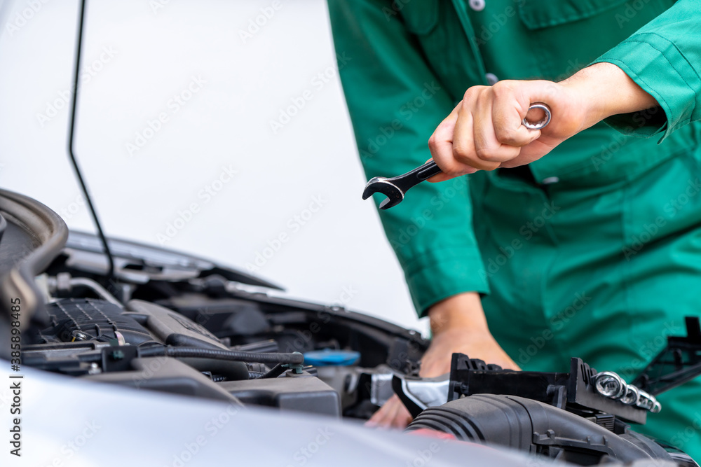 Professional mechanic hand providing car repair and maintenance service in auto garage. Car service 